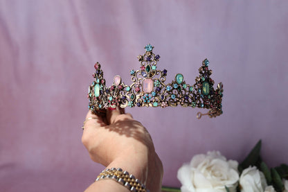 a woman is holding a tiara in her hand