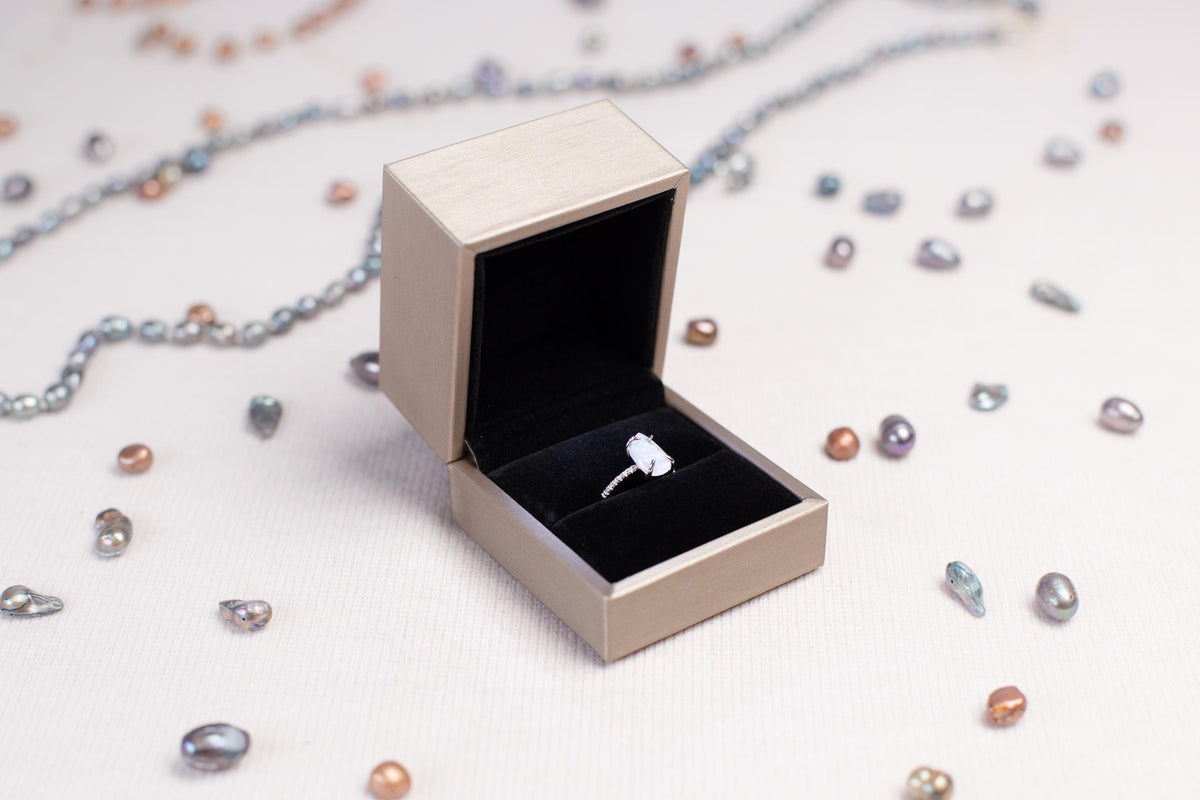 a ring sits inside of a box on a chain