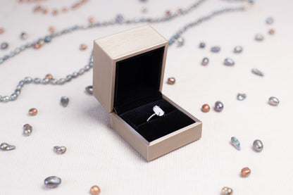 a ring sits inside of a box on a chain