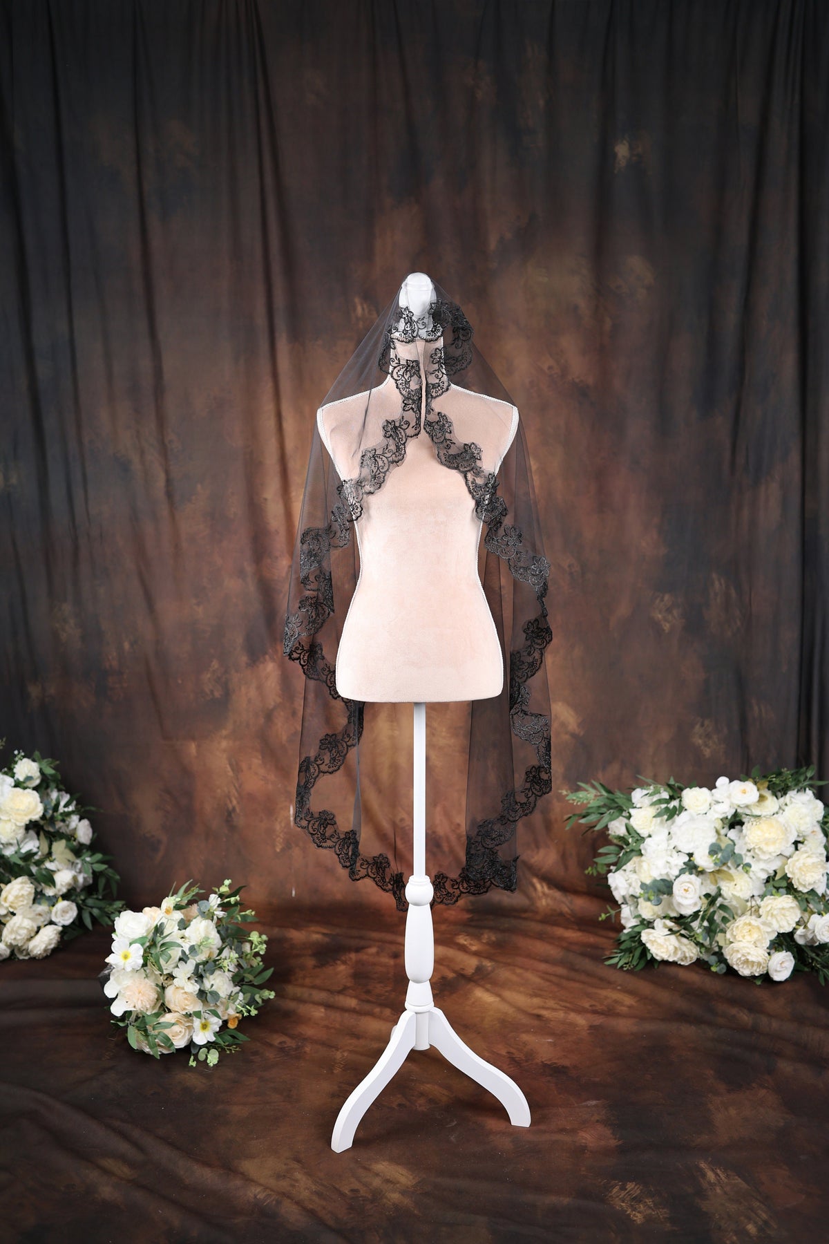 a white mannequin with a black veil and flowers