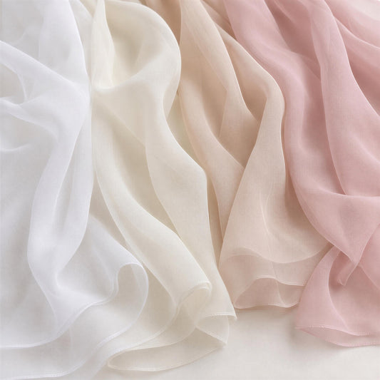 a close-up view of three different colored silks or fabrics, including white, light pink, and light brown, arranged in a horizontal row.
