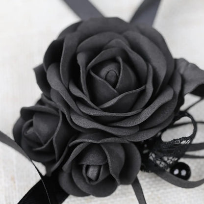 A close-up image of a black rose flower with a lace bow.