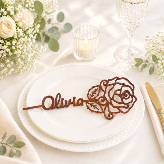 a table setting with a white plate, a wooden nameplate, and a glass of wine.