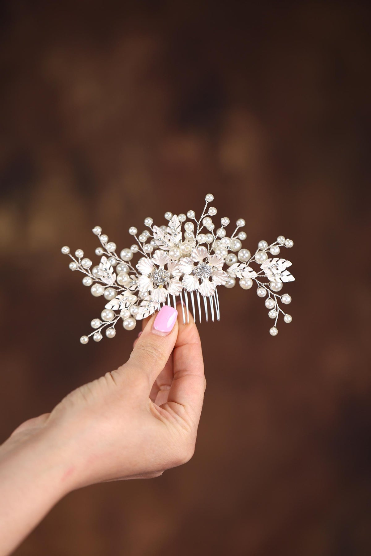 a hand holding a hair comb with flowers on it