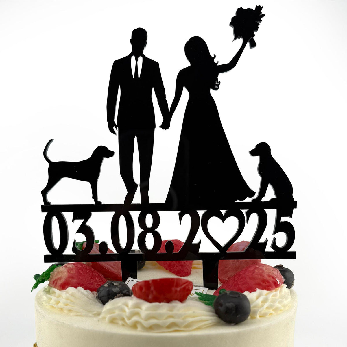 a cake with a silhouette of a bride and groom and a dog