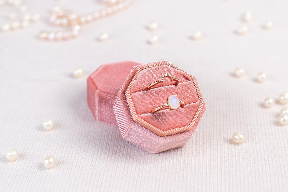 a pink ring box sitting on top of a table