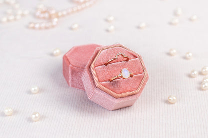 a pink ring box sitting on top of a table