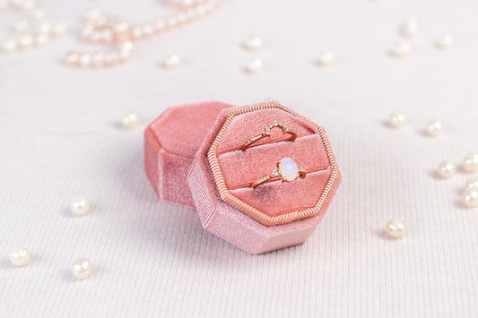 a pink ring box sitting on top of a table