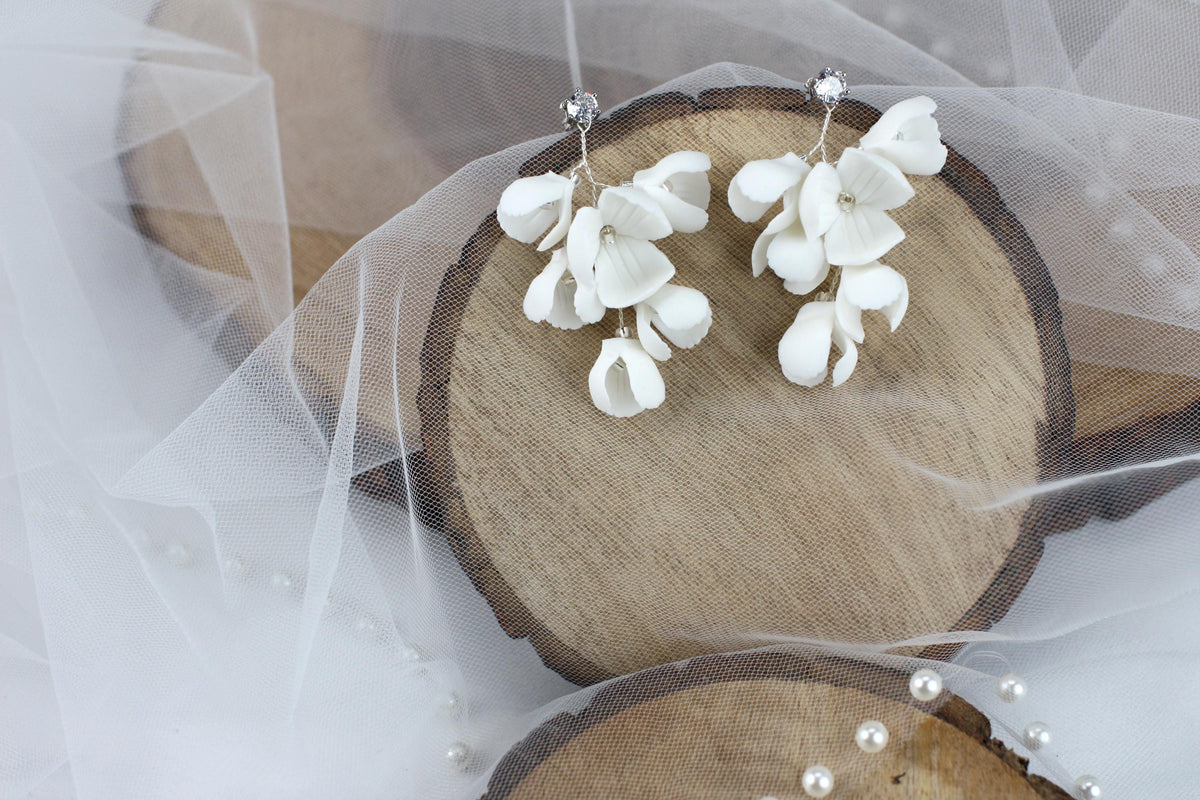 a pair of white flowers are on a piece of wood