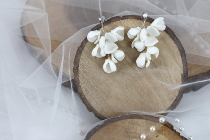 a pair of white flowers are on a piece of wood