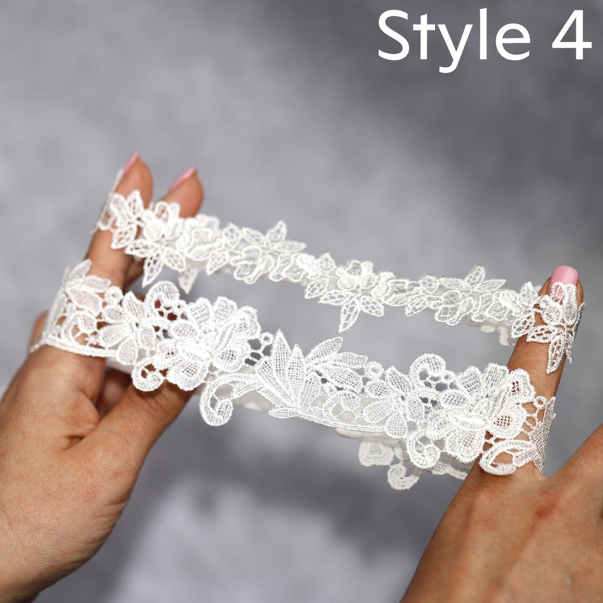 a pair of hands holding a piece of white lace