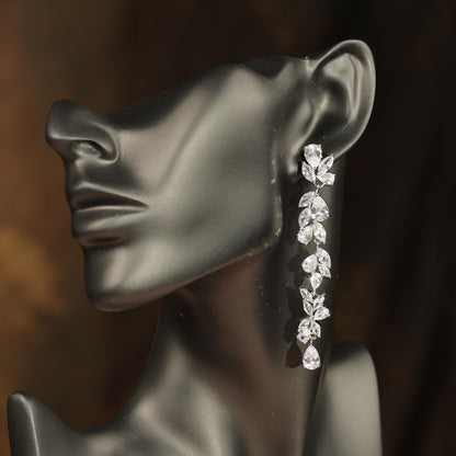 A close-up of a mannequin head wearing a pair of elegant diamond earrings.
