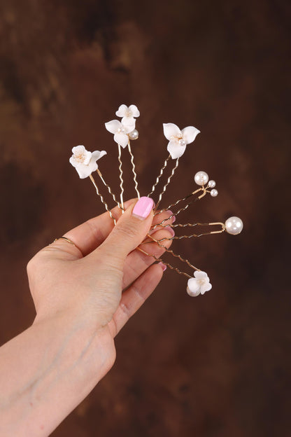 a woman's hand holding a bunch of white flowers
