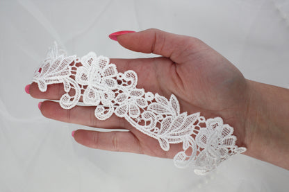a woman's hand holding a piece of white lace