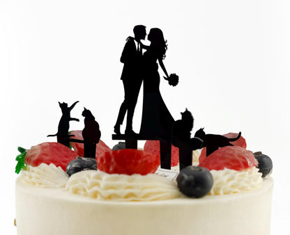 A silhouette of a bride and groom on top of a cake, surrounded by various fruit and decorative elements.