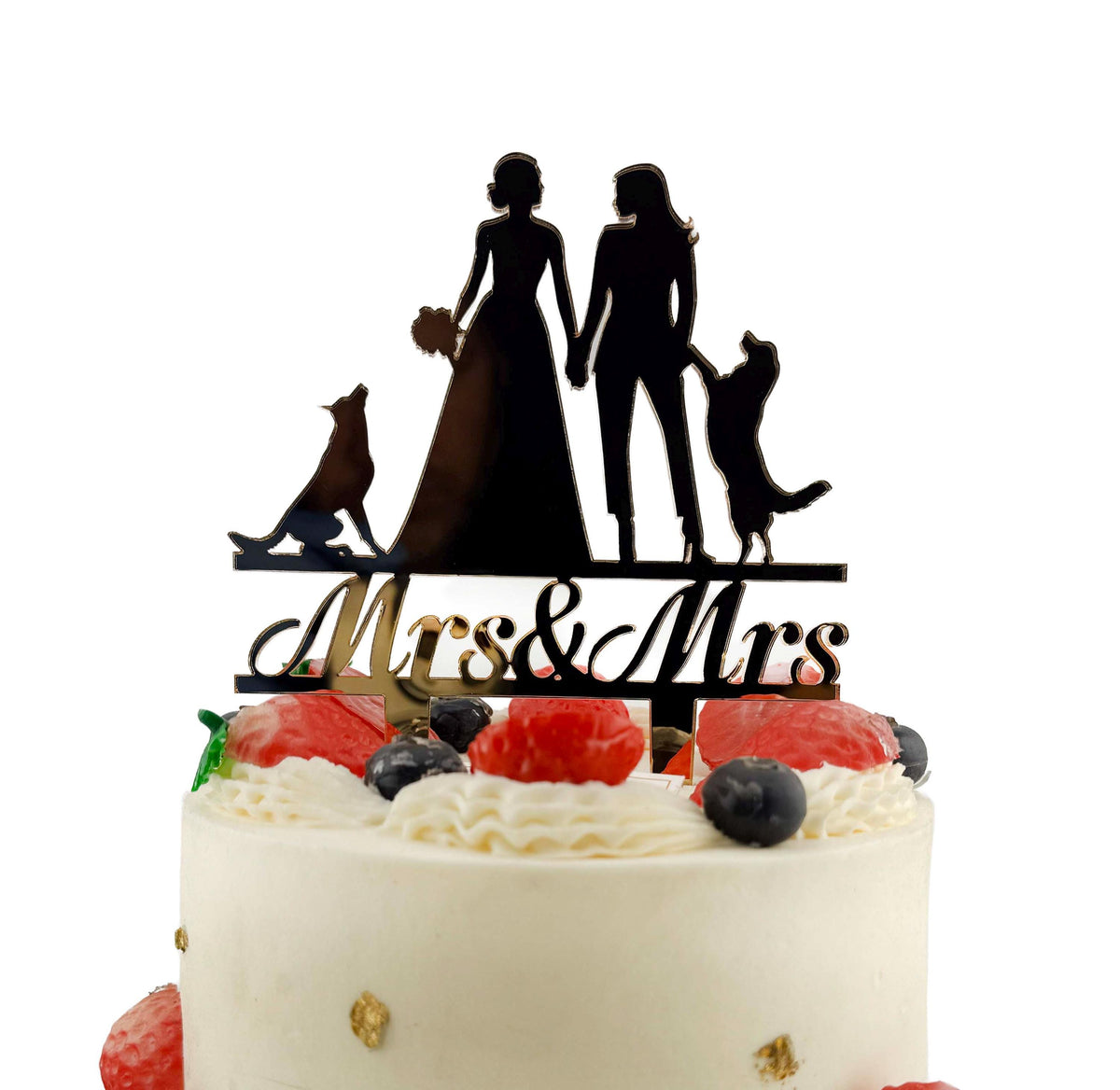 A white wedding cake with a black silhouette of a bride and groom on top, along with a "Mrs & Mrs" sign.