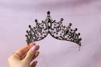a woman is holding a tiara in her hand