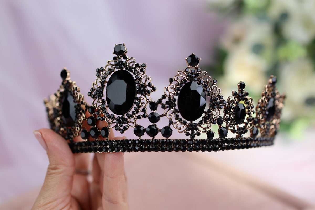 a woman holding a tiara with black stones on it