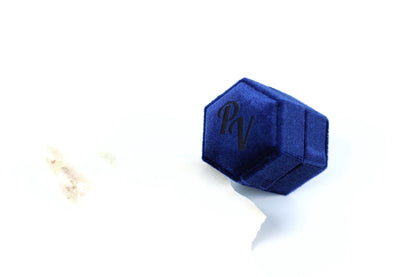 A blue hexagonal box with the letters "PV" embossed on it, placed on a white surface.