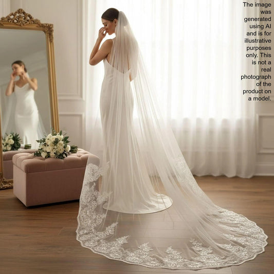 A bride in a white wedding dress stands in front of a mirror, her long veil flowing behind her. She appears to be in the process of putting on her veil, with a bouquet of flowers nearby.