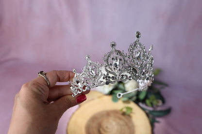 a woman is holding a tiara in her hand