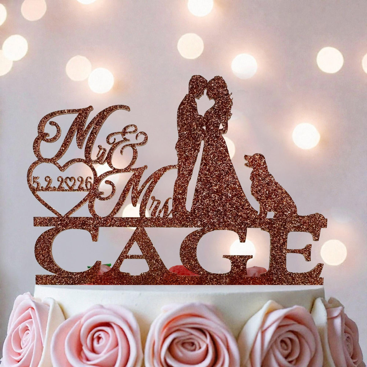 A wedding cake with a glittery topper that says "Mr & Mrs CAGE" and features silhouettes of a bride and groom.