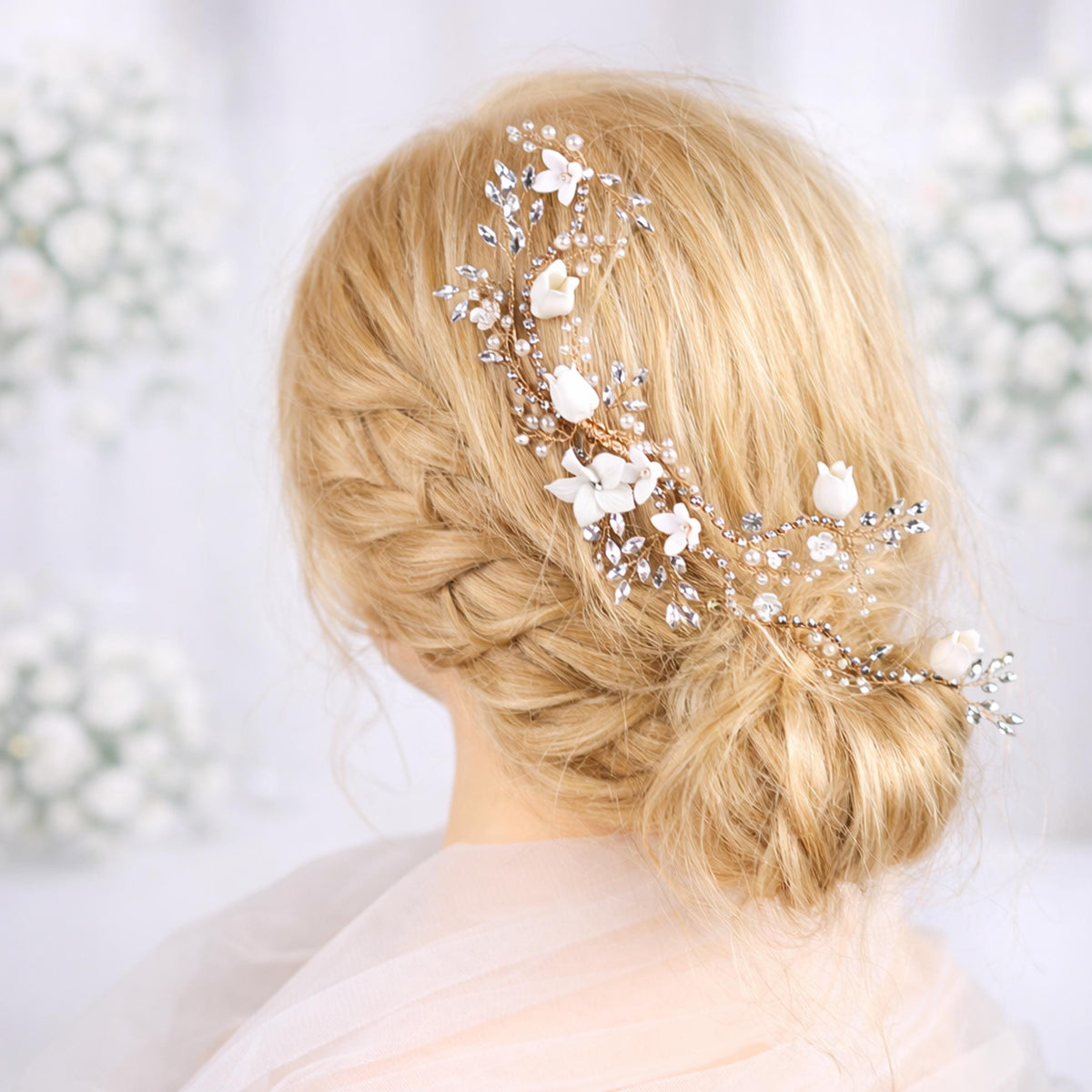 A close-up of a woman's blonde hair with a decorative hair accessory featuring white flowers and crystals.