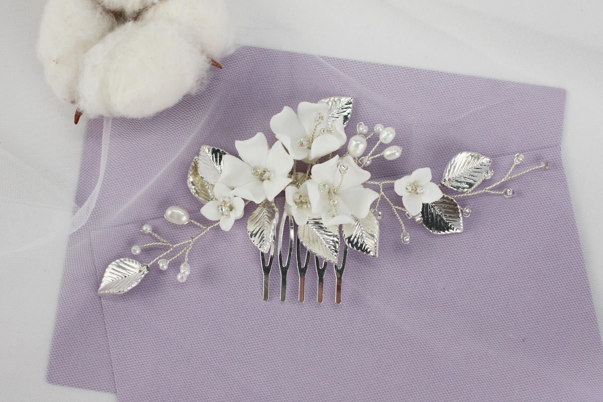 a hair comb with flowers and leaves on a purple cloth