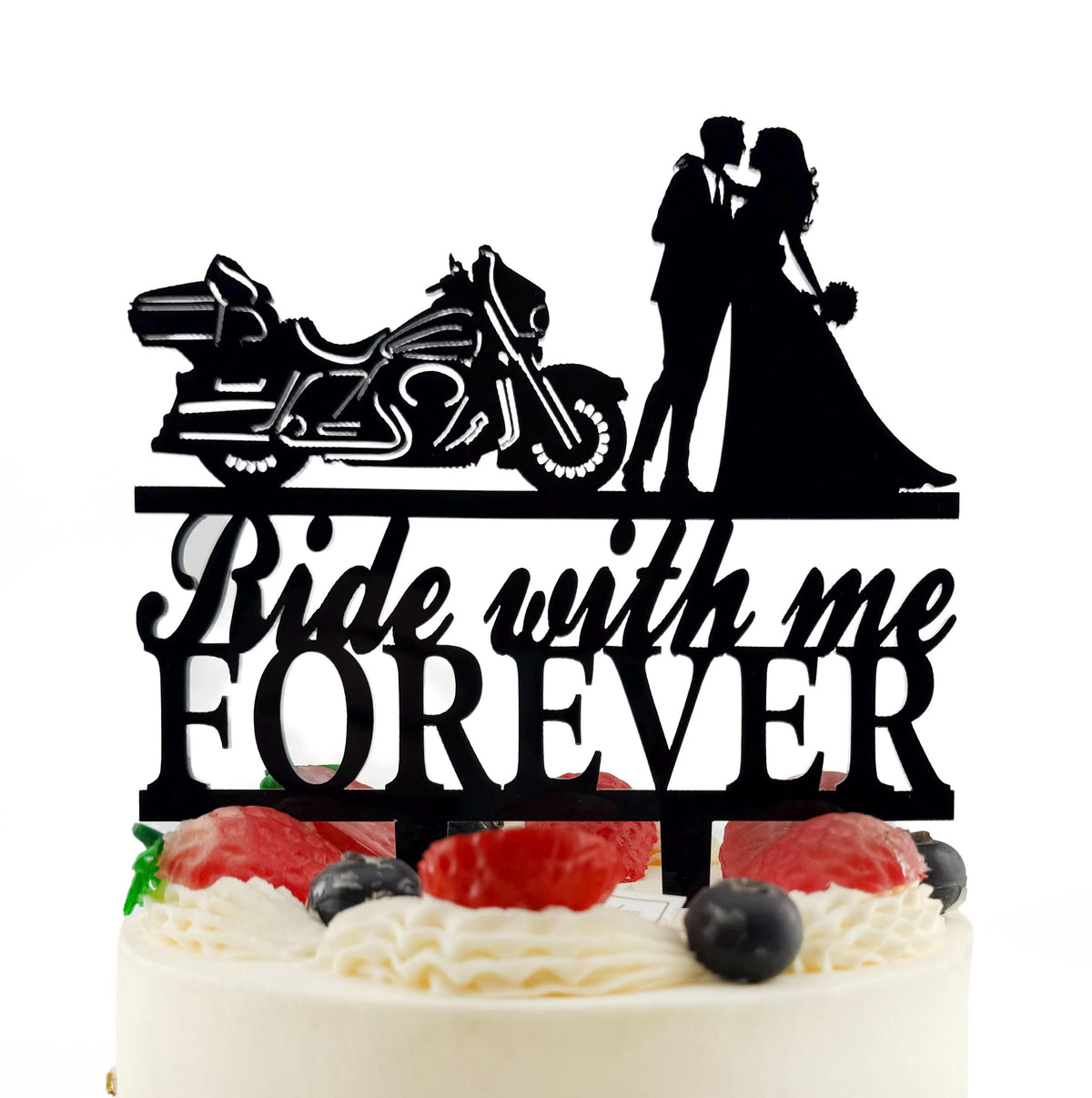 A black silhouette of a couple embracing a motorcycle on a cake topper, with the words "Ride with me Forever" written below.