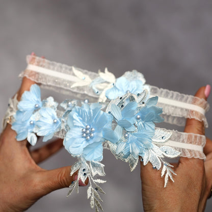 a pair of hands holding a pair of blue flowers