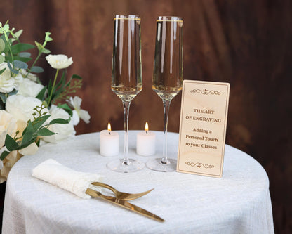 a table topped with two champagne flutes and a sign