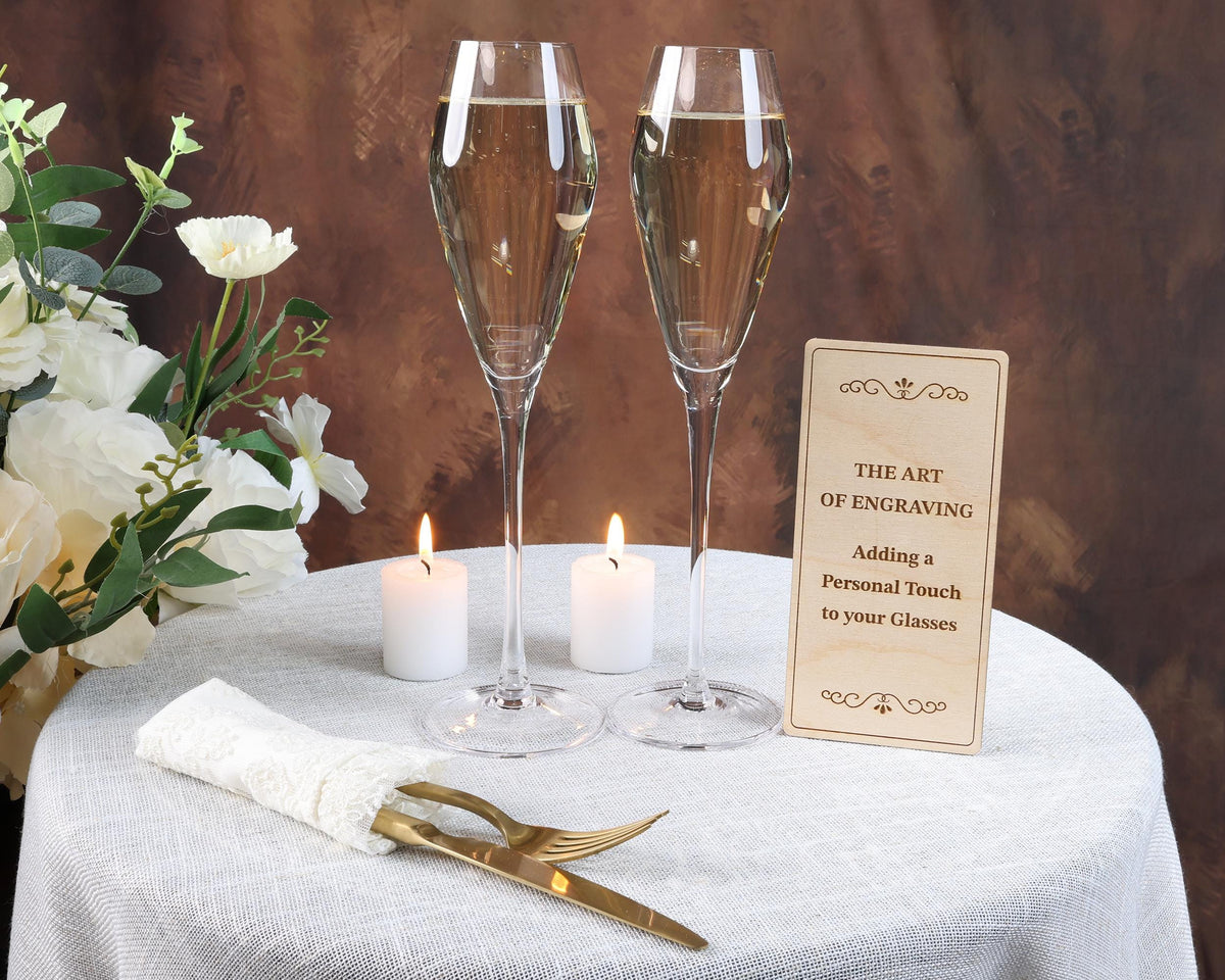 a table topped with two champagne flutes and a sign