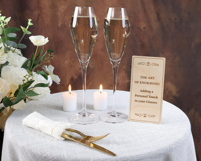 a table topped with two champagne flutes and a sign