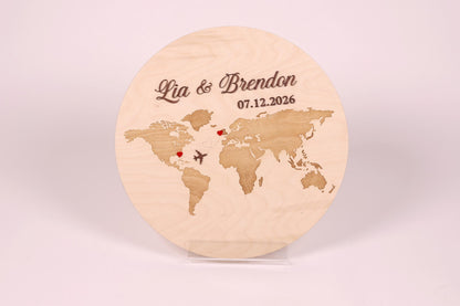 A wooden world map with the names 'Lia & Brandon' and the date '07.12.2026' engraved on it.