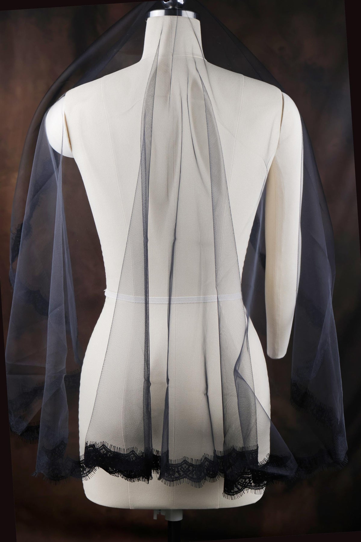the back of a white dress with black lace