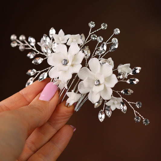 a woman's hand holding a hair comb with flowers on it