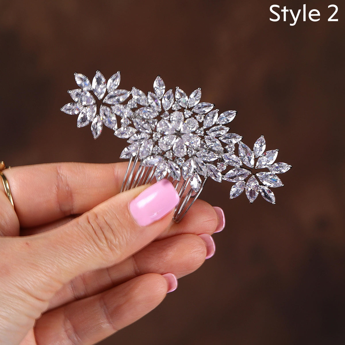 a woman's hand holding a crystal flower hair comb