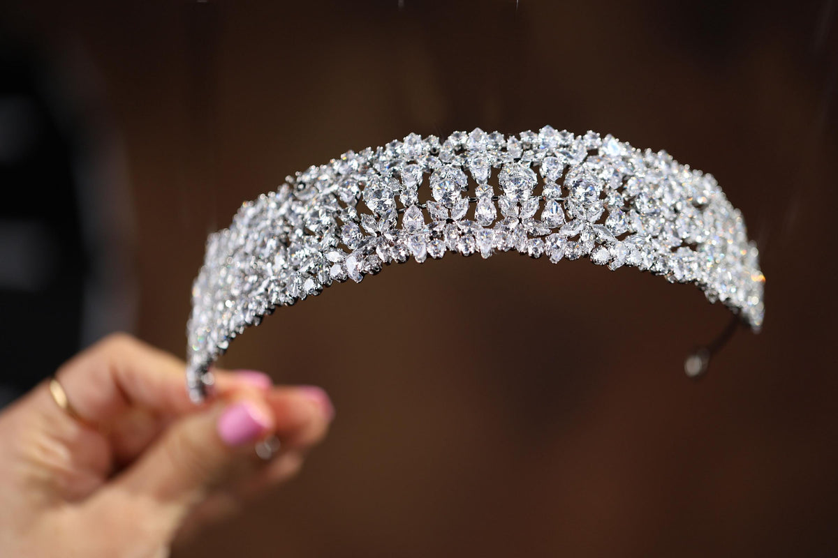 a close up of a person holding a tiara