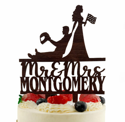 A silhouette of a man and a woman on a cake topper, with the text "Mr & Mrs MONTGOMERY" below them.