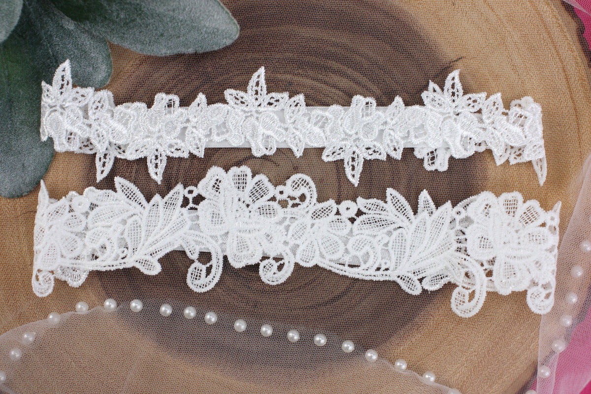 two white lace garters sitting on top of a piece of wood