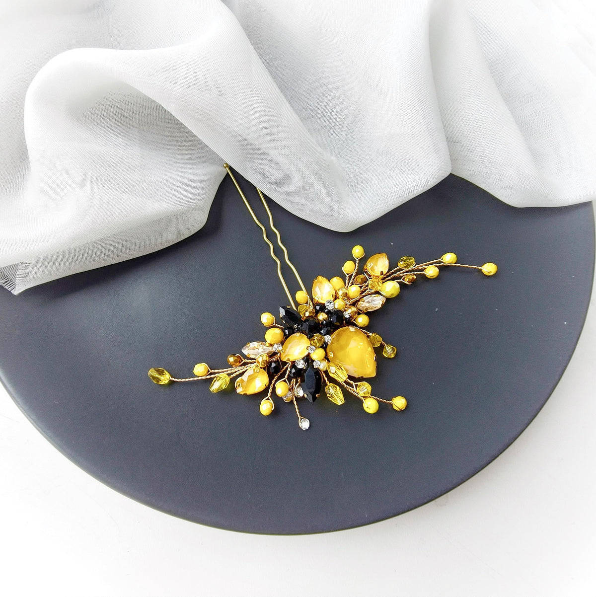 a black plate topped with a yellow and black necklace