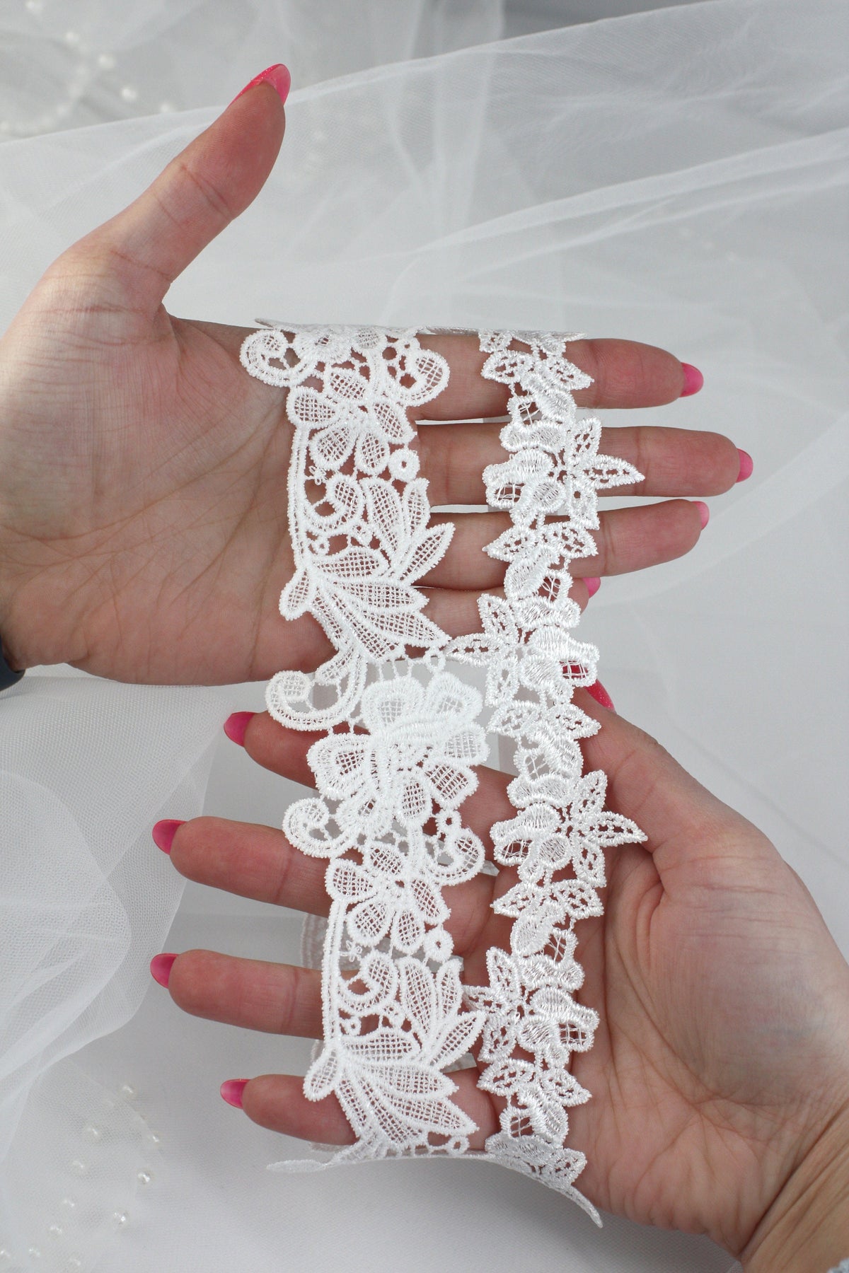 a woman's hand holding a piece of white lace