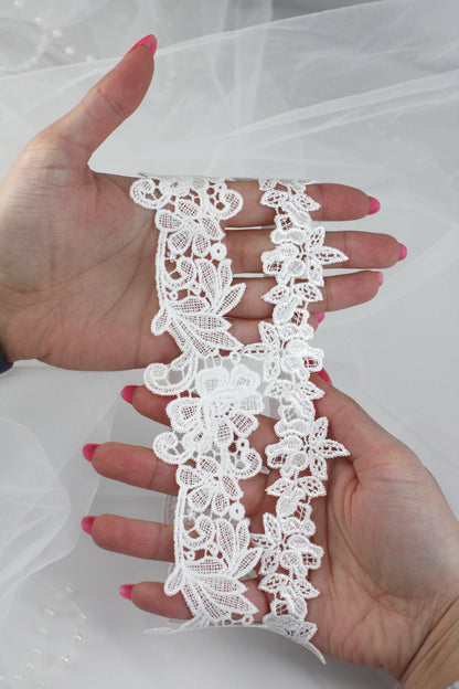 a woman's hand holding a piece of white lace