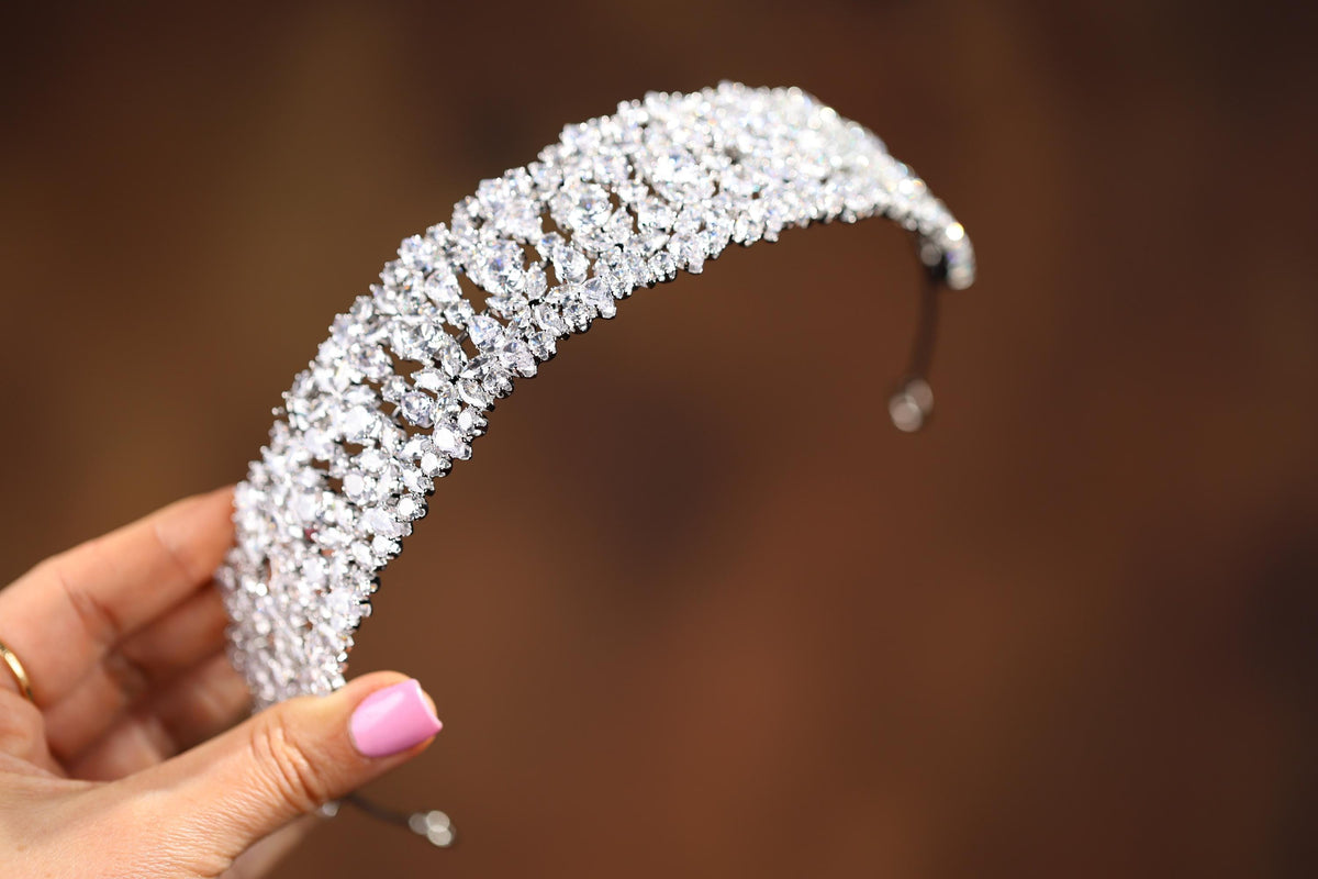 a close up of a person holding a tiara