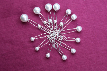 a bunch of pins sitting on top of a purple cloth