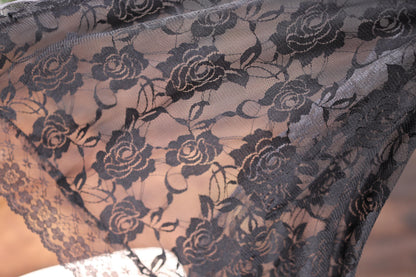 a close up of a black lace with flowers on it