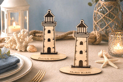 two wooden lighthouse stands placed on a table, surrounded by various decorative items such as a candle, a vase, and some seashells.