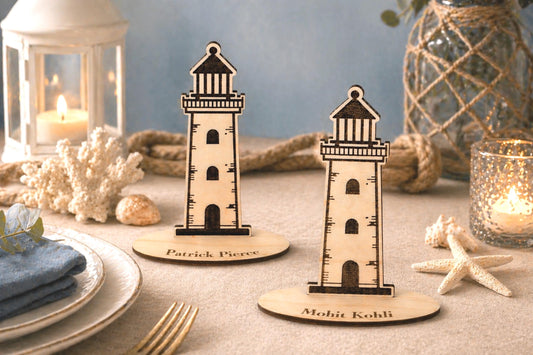 two wooden lighthouse stands placed on a table, surrounded by various decorative items such as a candle, a vase, and some seashells.
