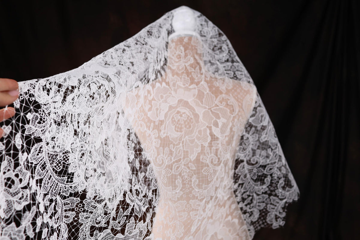 a woman is holding a wedding dress on a mannequin
