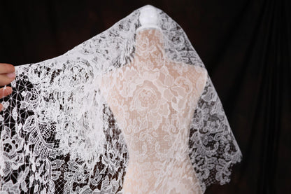 a woman is holding a wedding dress on a mannequin
